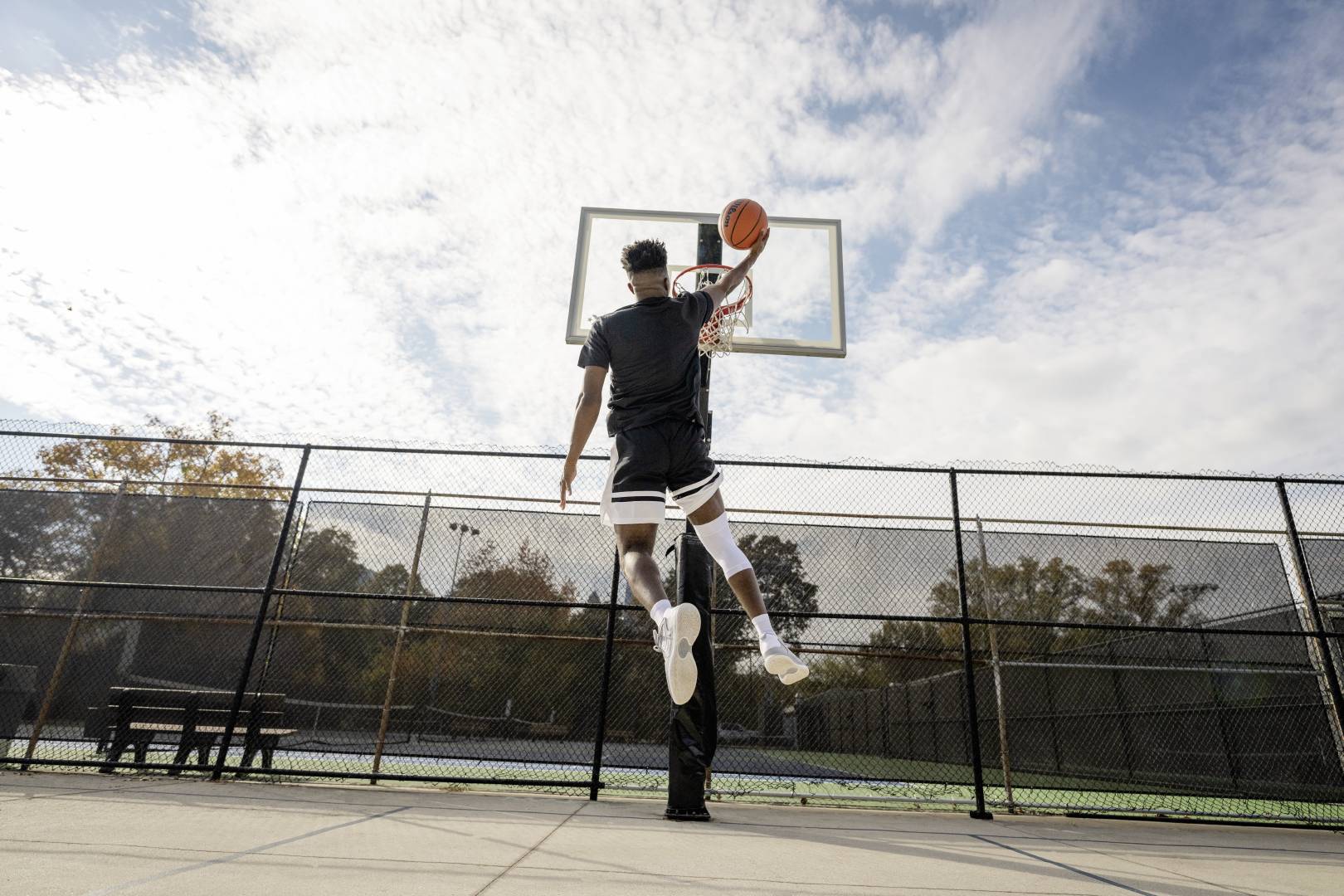 Basketball players with a white knee band during the Dunking on a streetball field