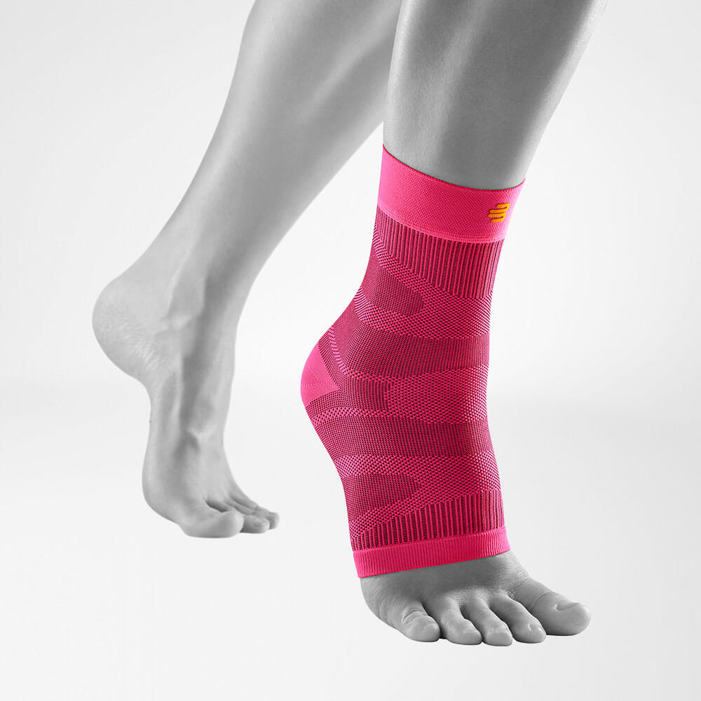 Complete view of the pink compression ankle support on a stylized gray leg