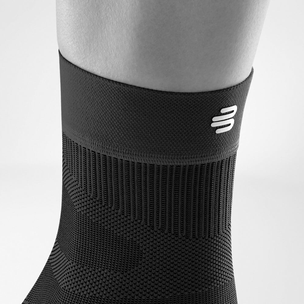 Detailed view of the upper area of ​​the Black Sportsleev for the ankle including a knitting and logo