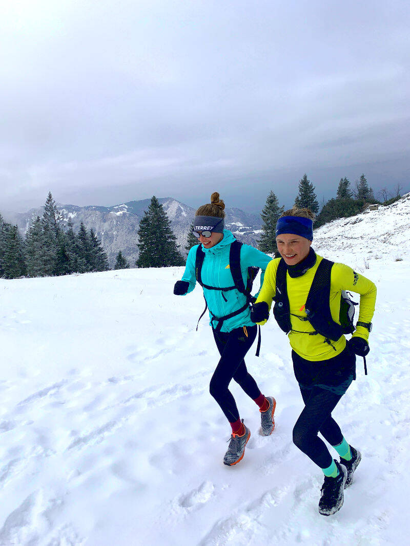 Hahner twins run with backpacks through a winter landscape