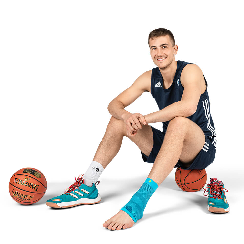 Player sits on a basketball with Sleeve