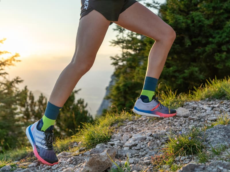 Langer with medium -length trail run socks runs up a mountain