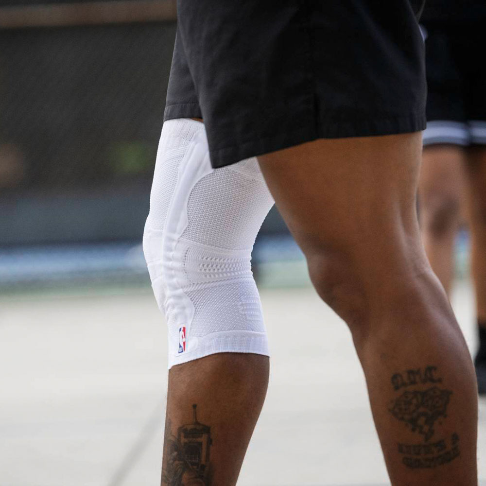 Excerpt from a basketball player with a white knee band with NBA logo