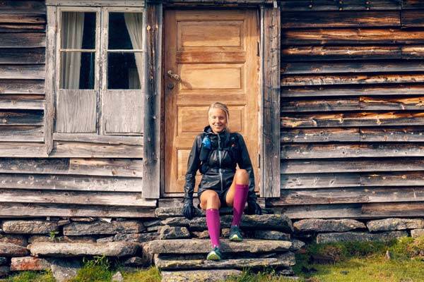 Traill runner Johanna Aström is sitting in front of a hut