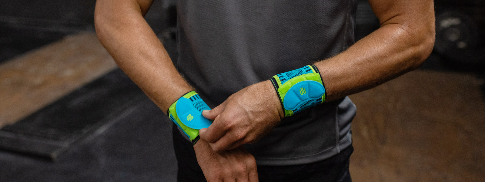 Man in the fitness room rightly pulls one of his wrist bandages