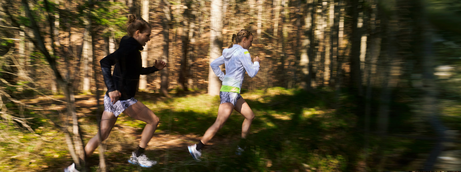 Two runners quickly run through the undergrowth with a slight image blur