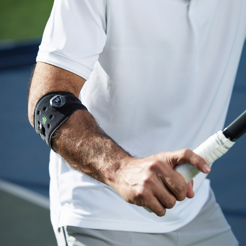 Forearm of a tennis player on the elbow, a bandage that holds the racket in hand