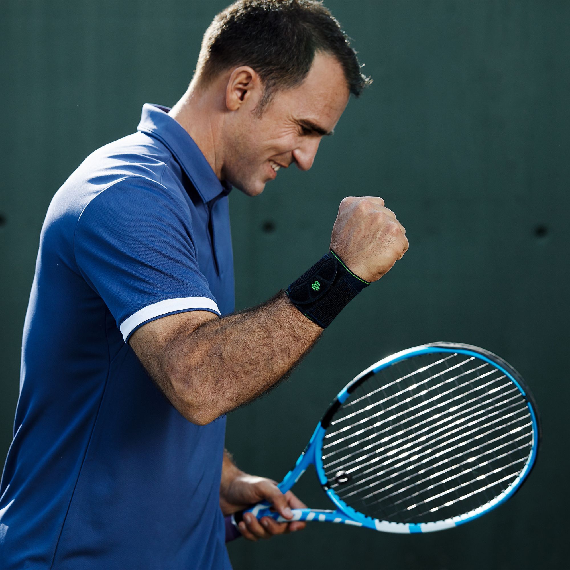 Tennis player in a winning pose with wrist bandage on the right wrist