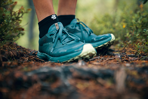 Close upper hiking shoes on a forest floor