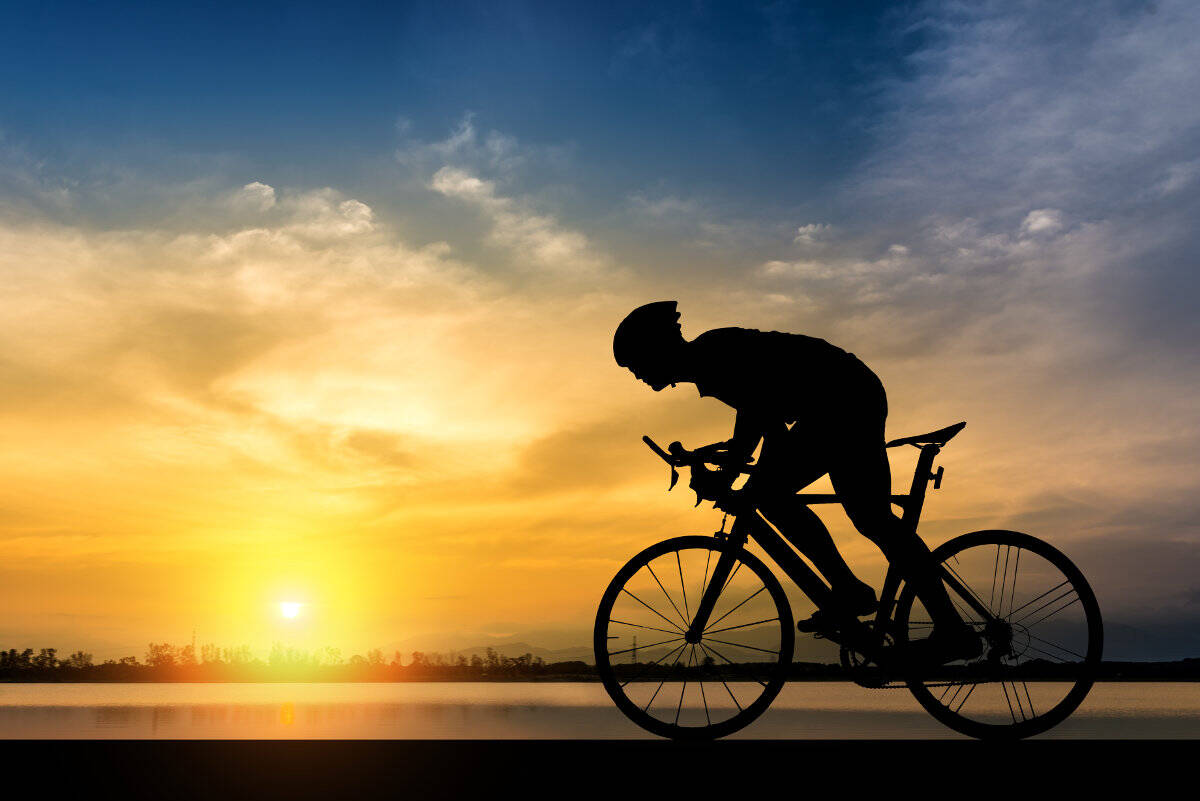 Silhouette of a cyclist in the shade at sunset