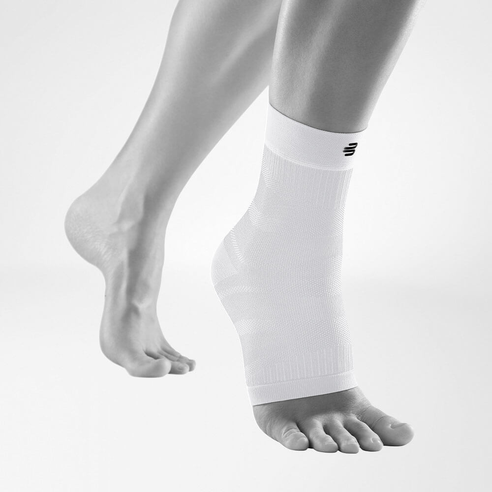 Complete view of the white compression ankle support on a stylized gray leg