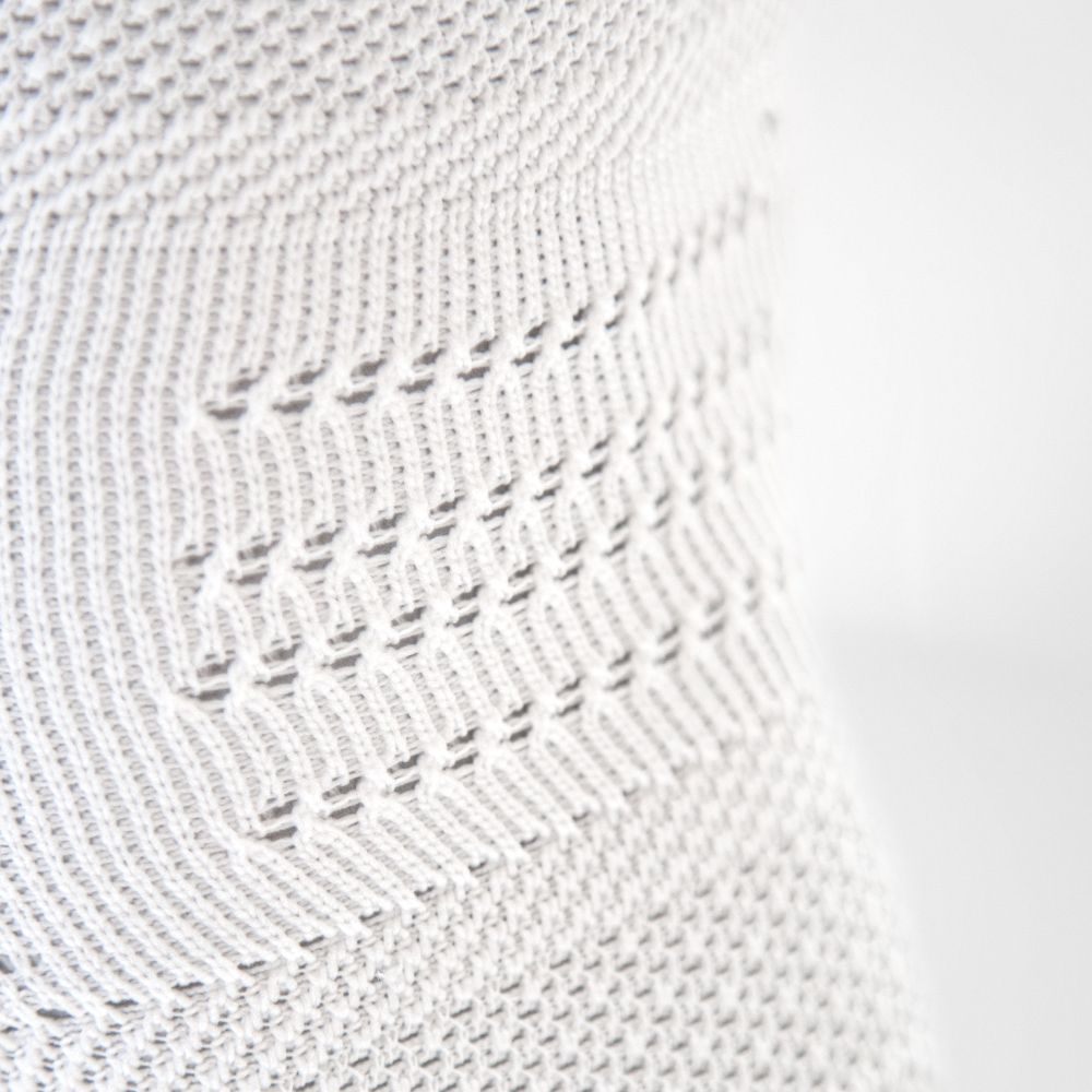 Detailed view of the breathable knitting in the knee of the white knee tandage for the sports NBA version