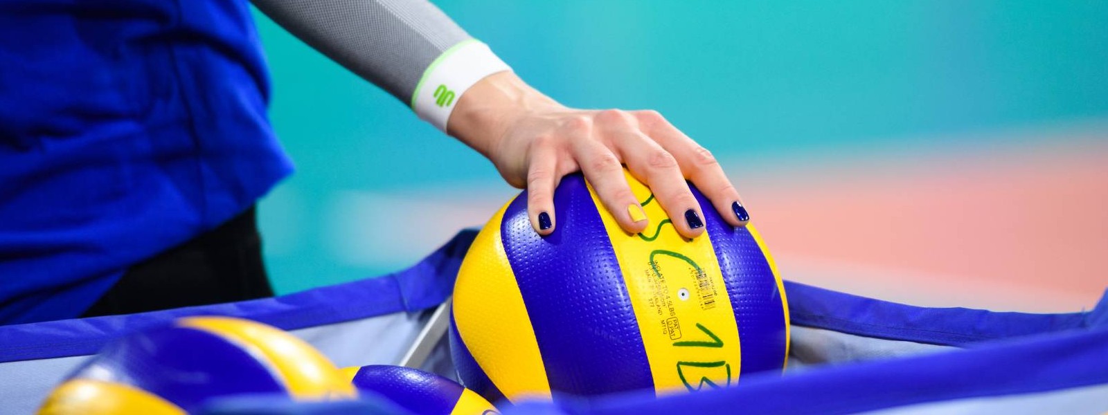 Volleyball player with white arm Sleeves grabs a volleyball