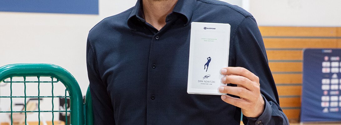 Dirk Nowitzki shows the packaging of the Knee Sleeves of Dirk Nowitzki Edition in the camera